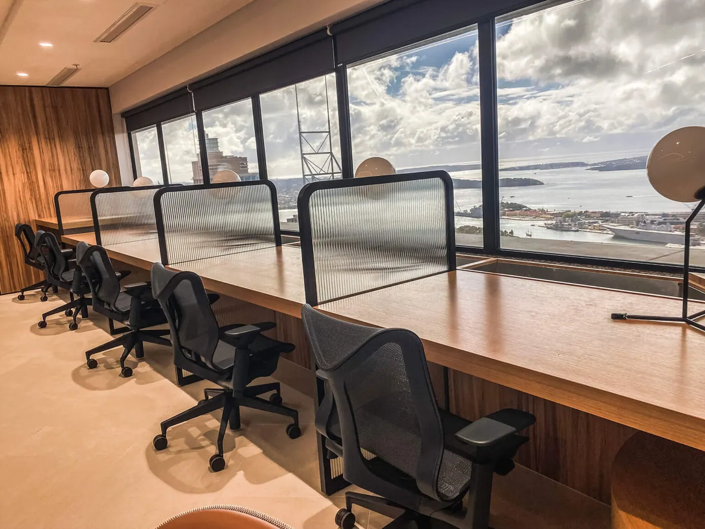 Office workstations beside windows fitted with glare and heat control film